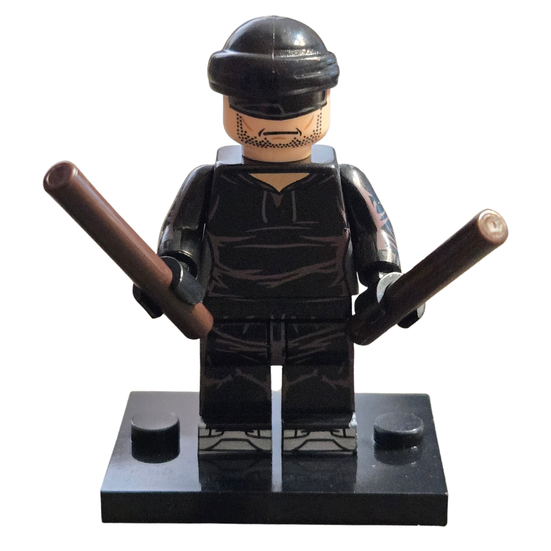 Toy figure in black tactical gear with batons on a white background