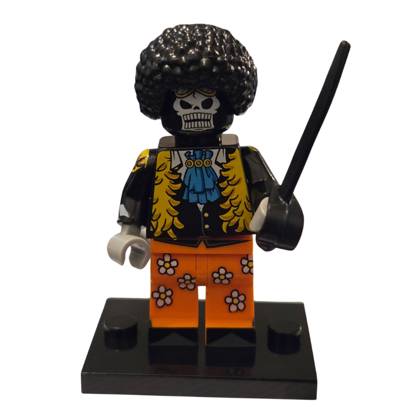 Toy figure with a skull head, colorful jacket, and orange pants on a white background