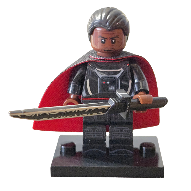 Toy figure with a red cape and sword on a white background