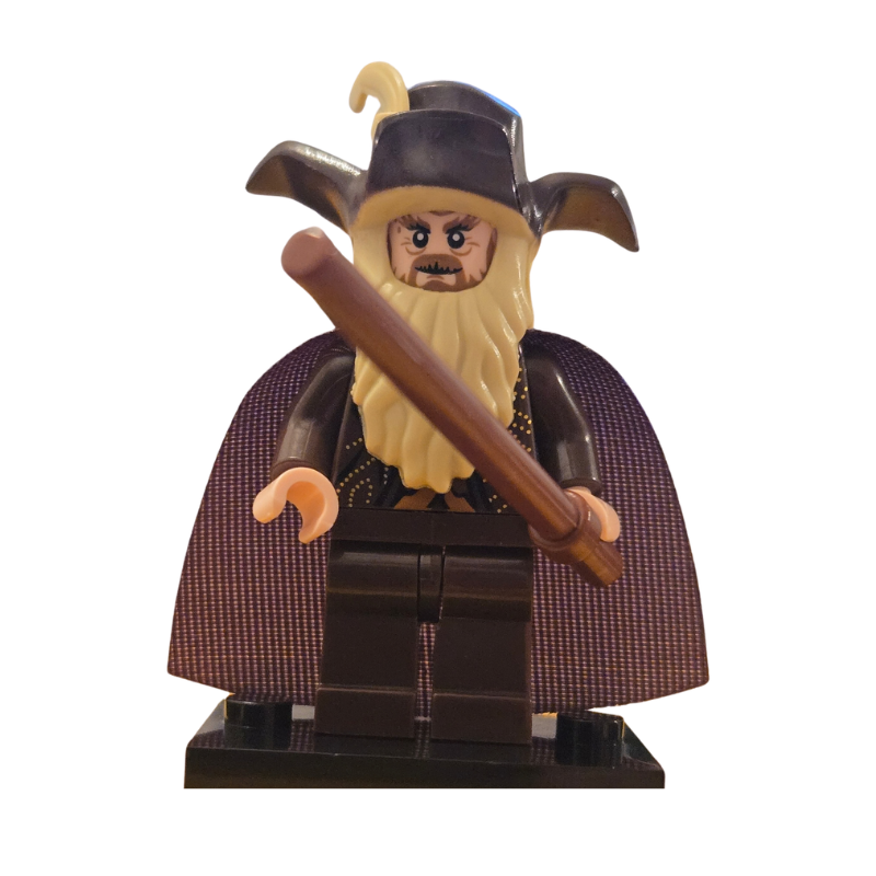 Toy figure of a character with a long beard and hat holding a staff on a white background