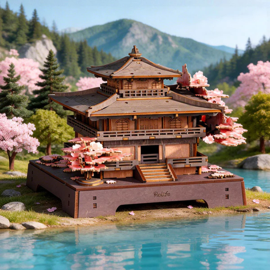 Model of a traditional Japanese pagoda with cherry blossom trees and mountains in the background
