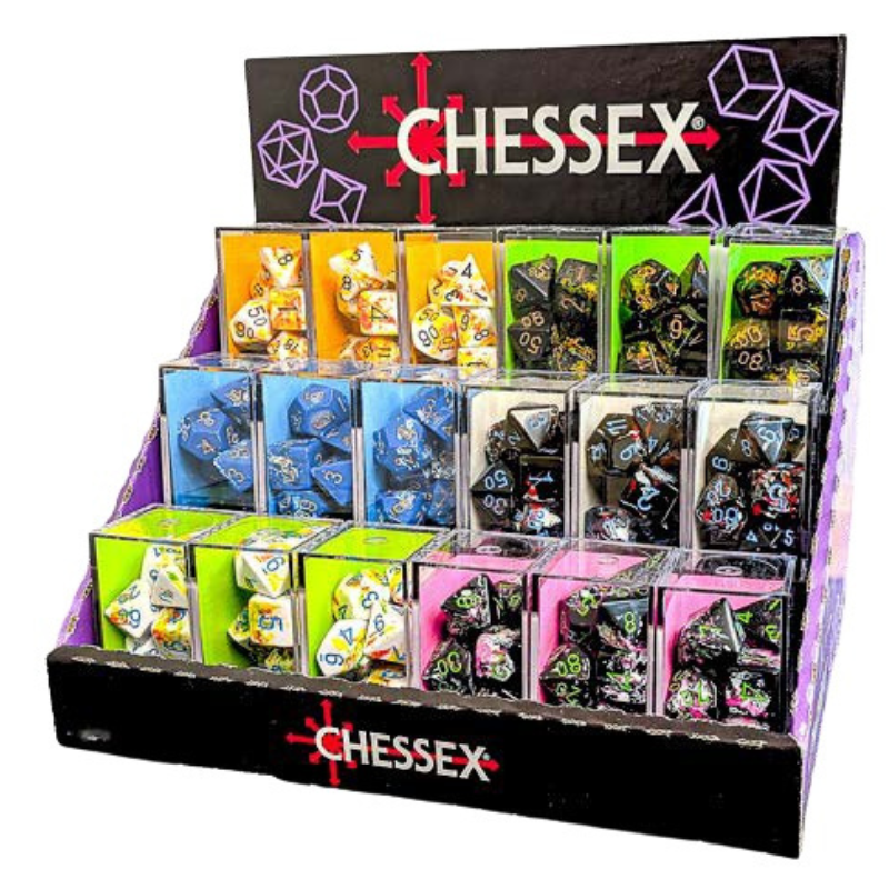 A CHESSEX branded display stand filled with multiple boxed sets of polyhedral gaming dice. The stand has a black front panel with the CHESSEX logo and a dark top sign with purple geometric outlines.