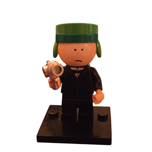 Toy figure with a green hat and black outfit holding a golden object on a white background