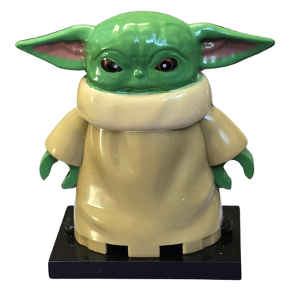 Toy figure of a character with green skin and large ears on a white background