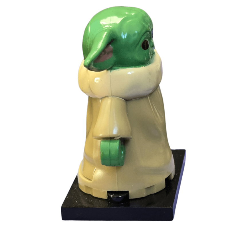 Green and beige character on a black stand with a white background