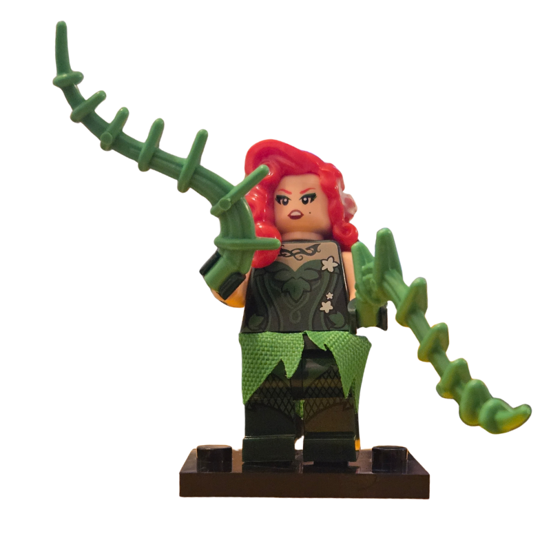Toy figure with red hair and green costume holding a weapon on a white background