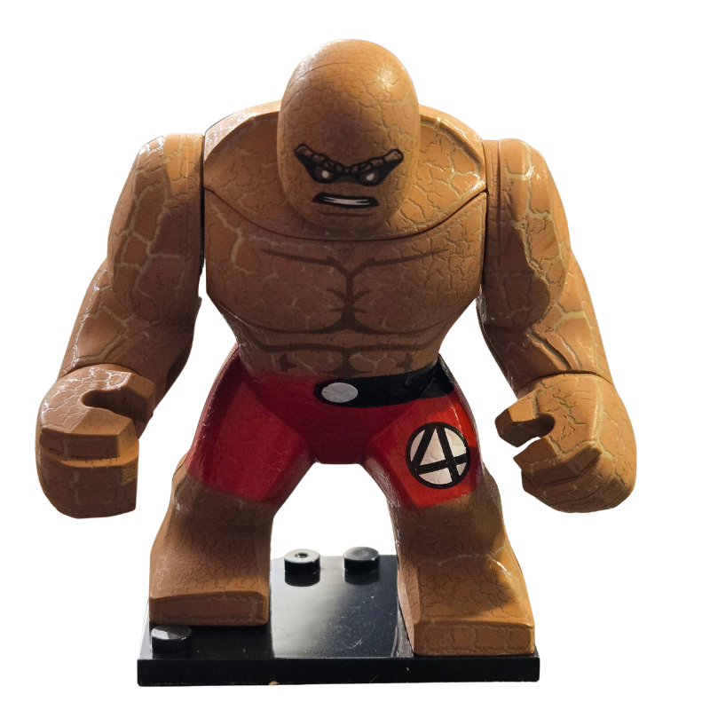 Brown superhero figure with red pants and a black belt on a white background