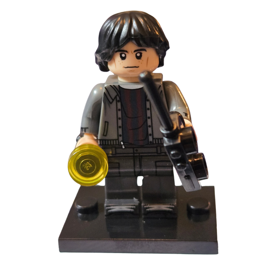 LEGO figure of a character holding a golden disc and a rifle on a white background