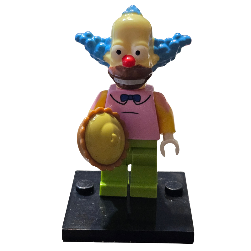 Toy figure with blue hair, red nose, and yellow outfit on a white background