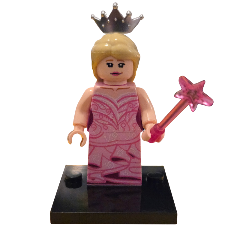 Toy figure of a princess with a pink dress, crown, and wand on a white background