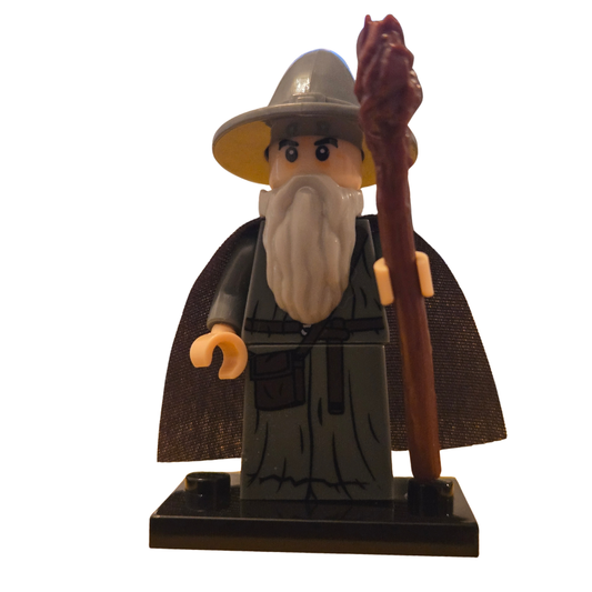 Toy figure of a wizard with a hat, beard, and staff on a white background