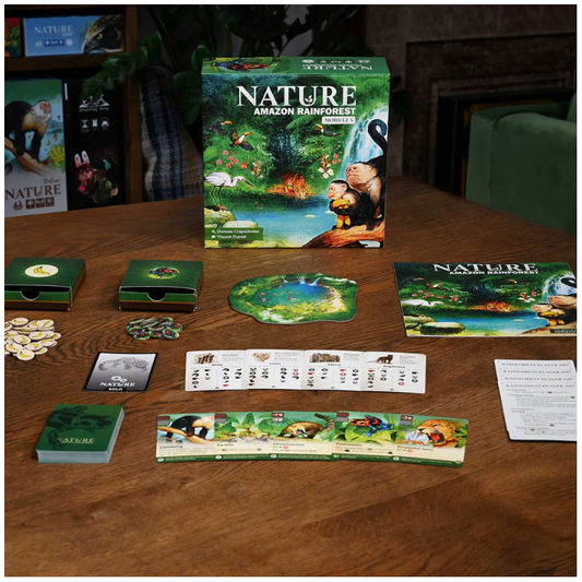 The board game 'Nature: Amazon Rainforest' and its components are displayed on a wooden table, including the main game box, play money, cards, tokens, and a river track. The background shows a dark, cozy room setting.
