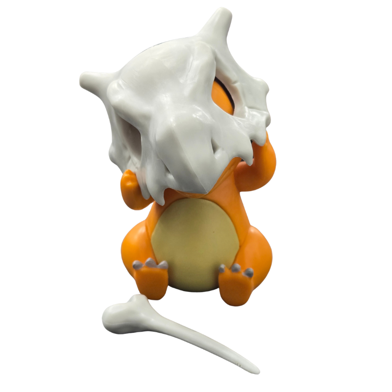 Charmander figurine with its white bone accessory, shown against a plain white background.