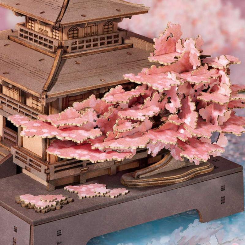 Wooden model of a traditional building with cherry blossom trees in front