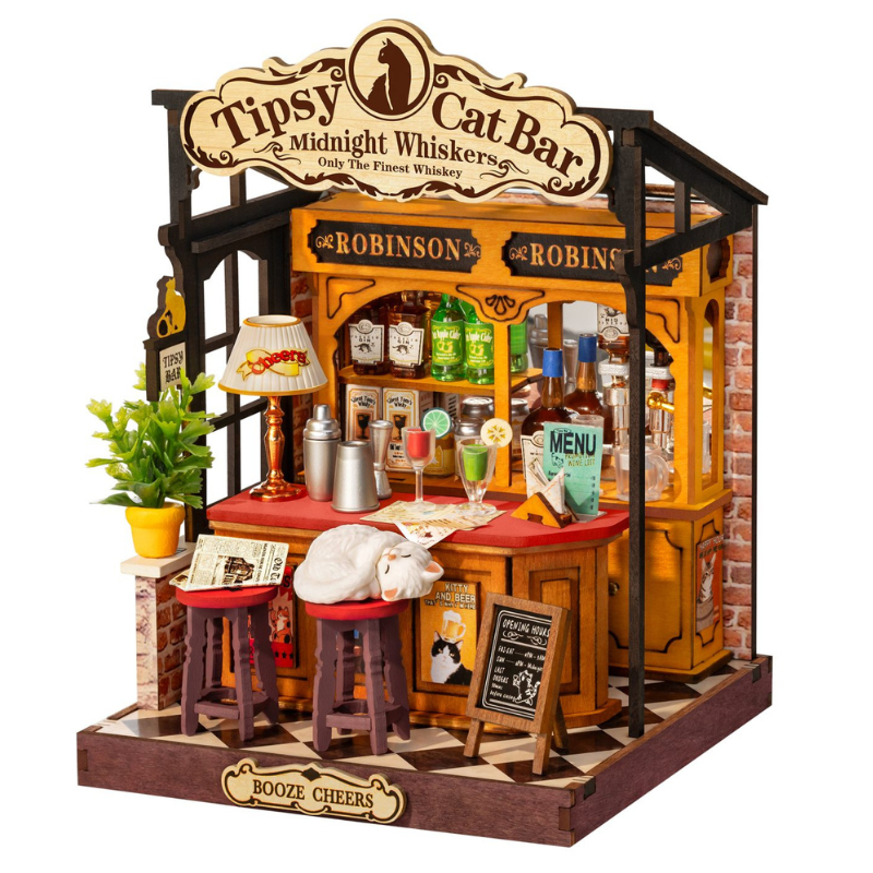 A miniature wooden gift box shaped like a bar called 'Tipsy Cat Bar', featuring a yellow and brown wood-grain design, miniature bottles, stools, a small potted plant, and themed decorations on a white background.