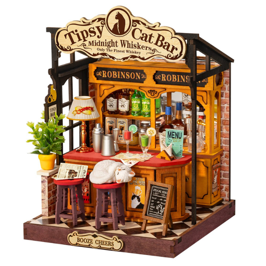 A miniature wooden gift box shaped like a bar called 'Tipsy Cat Bar', featuring a yellow and brown wood-grain design, miniature bottles, stools, a small potted plant, and themed decorations on a white background.